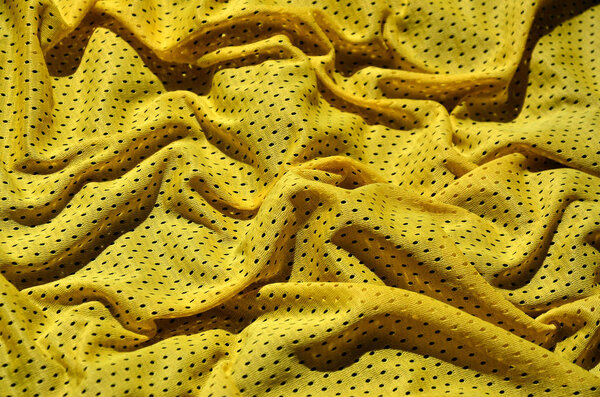 Yellow sport clothing texture background. Вид сверху на текстильную поверхность из желтой ткани. Яркая баскетбольная рубашка. Текстовое пространство
