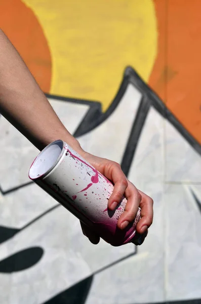 Foto de una chica con latas de pintura en aerosol en las manos sobre un fondo de pared de graffiti — Foto de Stock