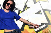 Картина, постер, плакат, фотообои "photo of a girl with aerosol paint cans in hands on a graffiti wall background", артикул 155897454