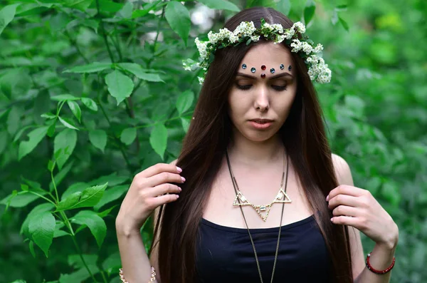 Portrait d'une jeune fille émotionnelle avec une couronne florale sur la tête et des ornements brillants sur le front — Photo