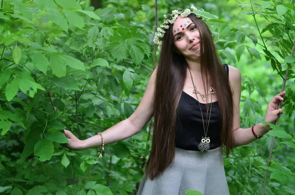 Портрет эмоциональной девушки с цветочным венком на голове и блестящими орнаментами на лбу — стоковое фото