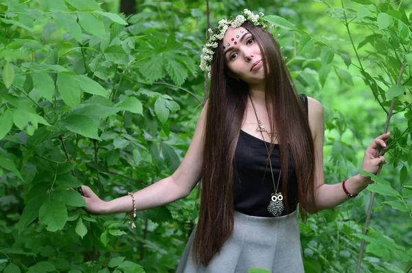 Портрет эмоциональной девушки с цветочным венком на голове и блестящими орнаментами на лбу — стоковое фото
