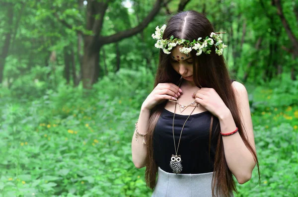 Çiçek çelenk başında ve alnındaki parlak süsler ile duygusal bir genç kız portresi