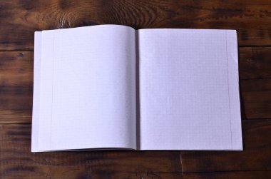 Bir temiz beyaz okul çek defteri kahverengi ahşap arka plan üzerinde fotoğraf. Fikir veya ileti kavramı. Metin için yeterince boş alana
