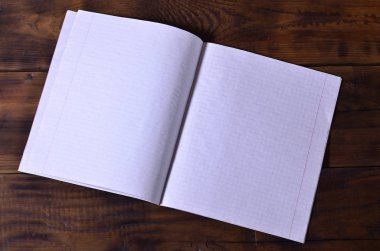 Bir temiz beyaz okul çek defteri kahverengi ahşap arka plan üzerinde fotoğraf. Fikir veya ileti kavramı. Metin için yeterince boş alana