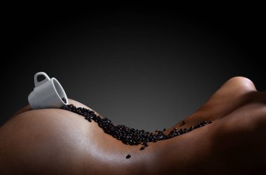 Bir fotoğrafı bir güzel ve seksi çıplak kadın bedeni üzerinde yatıyor sıcak kahve ile lots-in kahve çekirdekleri, beyaz bir fincan. Kahve içecek kullanımı hakkında erotik fotoğraf