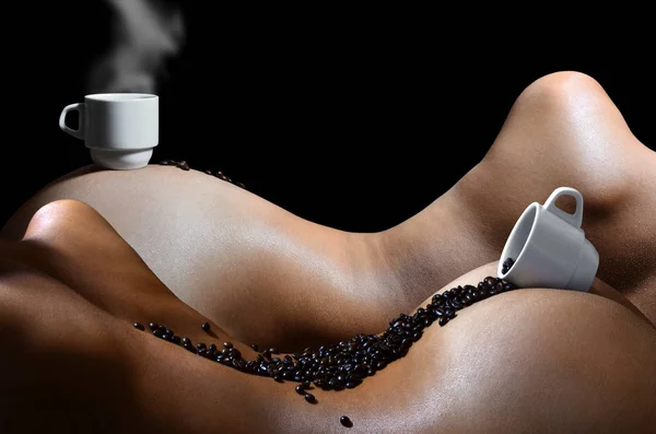 A photograph of two white cups of hot coffee with lots of coffee beans, which lie on two beautiful and sexy naked female bodies. Erotic photo about the use of coffee drinks