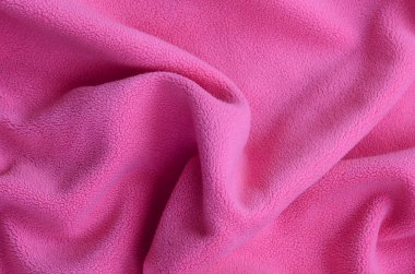 Tüylü pembe Polar kumaş battaniye. Hafif pembe yumuşak peluş Polar malzeme bir sürü kabartma kıvrımları ile bir arka plan