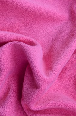 Tüylü pembe Polar kumaş battaniye. Hafif pembe yumuşak peluş Polar malzeme bir sürü kabartma kıvrımları ile bir arka plan