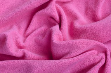 Tüylü pembe Polar kumaş battaniye. Hafif pembe yumuşak peluş Polar malzeme bir sürü kabartma kıvrımları ile bir arka plan