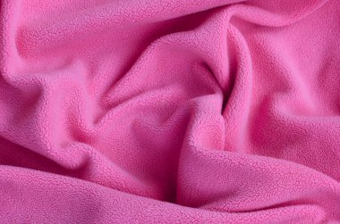Tüylü pembe Polar kumaş battaniye. Hafif pembe yumuşak peluş Polar malzeme bir sürü kabartma kıvrımları ile bir arka plan