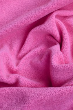 Tüylü pembe Polar kumaş battaniye. Hafif pembe yumuşak peluş Polar malzeme bir sürü kabartma kıvrımları ile bir arka plan