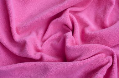 Tüylü pembe Polar kumaş battaniye. Hafif pembe yumuşak peluş Polar malzeme bir sürü kabartma kıvrımları ile bir arka plan