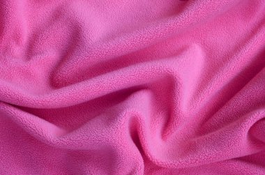Tüylü pembe Polar kumaş battaniye. Hafif pembe yumuşak peluş Polar malzeme bir sürü kabartma kıvrımları ile bir arka plan