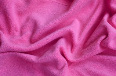 Tüylü pembe Polar kumaş battaniye. Hafif pembe yumuşak peluş Polar malzeme bir sürü kabartma kıvrımları ile bir arka plan