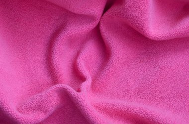 Tüylü pembe Polar kumaş battaniye. Hafif pembe yumuşak peluş Polar malzeme bir sürü kabartma kıvrımları ile bir arka plan