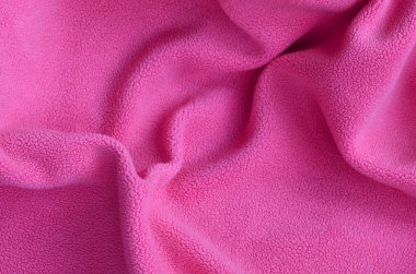 Tüylü pembe Polar kumaş battaniye. Hafif pembe yumuşak peluş Polar malzeme bir sürü kabartma kıvrımları ile bir arka plan