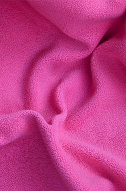 Tüylü pembe Polar kumaş battaniye. Hafif pembe yumuşak peluş Polar malzeme bir sürü kabartma kıvrımları ile bir arka plan