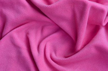 Tüylü pembe Polar kumaş battaniye. Hafif pembe yumuşak peluş Polar malzeme bir sürü kabartma kıvrımları ile bir arka plan