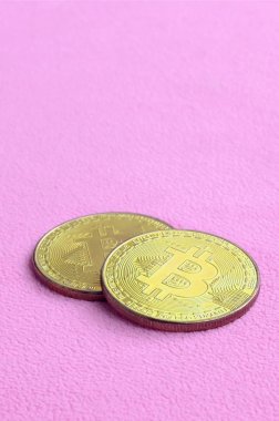 İki altın bitcoins yumuşak ve kabarık hafif pembe Polar kumaştan yapılmış bir battaniye yatıyor. Sanal Kripto para biriminin fiziksel görselleştirme