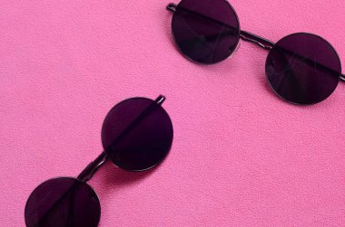 İle iki şık siyah güneş gözlüğü gözlük yalanlar üzerine bir battaniye yumuşak ve kabarık hafif pembe Polar kumaştan yapılmış yuvarlak. Kadın renklerde şık arka plan resmi