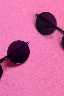 İle iki şık siyah güneş gözlüğü gözlük yalanlar üzerine bir battaniye yumuşak ve kabarık hafif pembe Polar kumaştan yapılmış yuvarlak. Kadın renklerde şık arka plan resmi