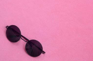 Şık siyah güneş gözlüğü gözlük yalanlar üzerine bir battaniye yumuşak ve kabarık hafif pembe Polar kumaştan yapılmış yuvarlak. Kadın renklerde şık arka plan resmi