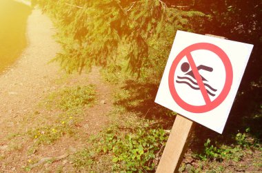 Bir ayağı ile yüzme yasağı ifade eden bir işaret. Bir çarpı kayan kişi işareti gösteriyor