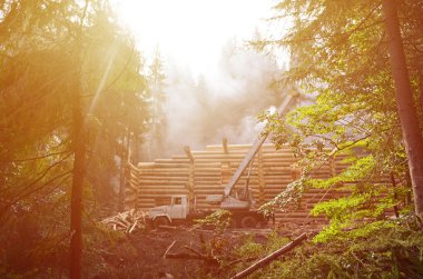 Silindir şeklinde Ahşap Kirişler gelen ahşap bir ev inşa süreci. Çalışır durumda vinç