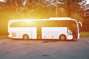 Turist otobüsü geziler için beyaz. Otobüs park yakınındaki bir park yerinde duruyor