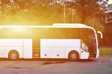 Turist otobüsü geziler için beyaz. Otobüs park yakınındaki bir park yerinde duruyor