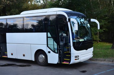 Turist otobüsü geziler için beyaz. Otobüs park yakınındaki bir park yerinde duruyor