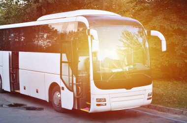 Turist otobüsü geziler için beyaz. Otobüs park yakınındaki bir park yerinde duruyor