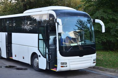 Turist otobüsü geziler için beyaz. Otobüs park yakınındaki bir park yerinde duruyor