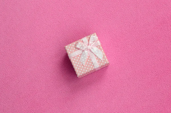 小さな弓とピンクの小さなギフト ボックスは 柔らかく 毛皮のような明るいピンクのフリース生地の毛布にあります あなたの素敵なガール フレンドにギフトのパッキング — ストック写真