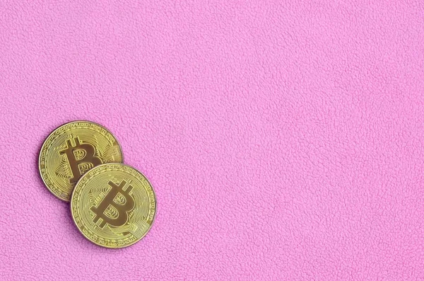 İki altın bitcoins yumuşak ve kabarık hafif pembe Polar kumaştan yapılmış bir battaniye yatıyor. Sanal Kripto para biriminin fiziksel görselleştirme
