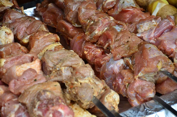 Raw meat and potatoes are planted on metal skewers. The process of cooking shish kebabs. Russian and Ukrainian camp food — Stock Image Raw Meat Potatoes Planted Metal Skewers Process Cooking Shish Kebabs Royalty Free Stock Images