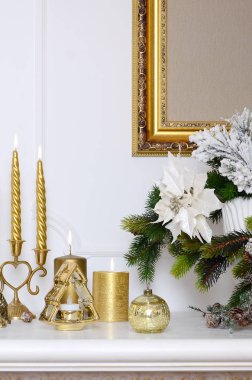 Yeni yıl ve Noel kompozisyon. Kalın mum, mum, çiçek ve duvarda asılı çerçeveli tuval pot