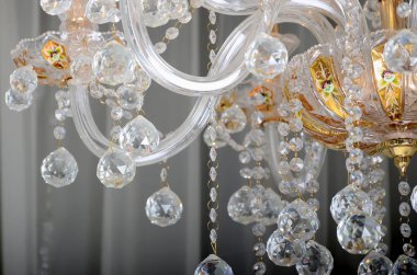 Close-up photo of the scenery on the old chandelier. Glass figures shine and reflect light with their faces clipart