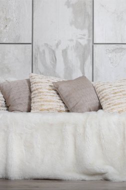 Kanepede bir mermer duvar arka planı büyük bir peluş örtü ile kaplıdır birçok yastıklar yalan