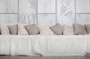 Kanepede bir mermer duvar arka planı büyük bir peluş örtü ile kaplıdır birçok yastıklar yalan