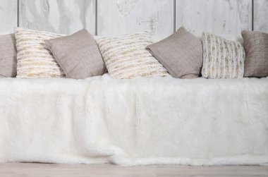 Kanepede bir mermer duvar arka planı büyük bir peluş örtü ile kaplıdır birçok yastıklar yalan