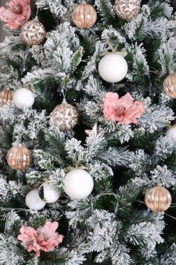 Noel ağacı yakın çekim dekorasyon. Dekorasyon ampul, karlı yeşil çam ağacı, pembe x-mas oyuncak ve ışıklar. Noel ve yeni yıl kutlama arka plan için kullanın