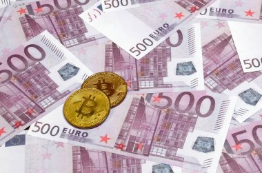 Bitcoins beş yüz euro banknot yığını üzerinde. Geleneksel para cryptocurrency kavramı karşı. Altın sikke üzerinde 500 euro faturaları. Yakın çekim