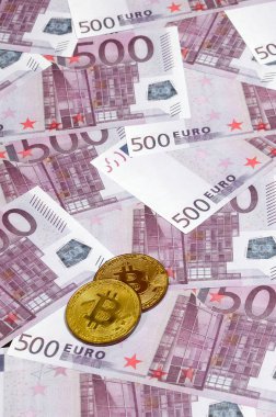 Bitcoins beş yüz euro banknot yığını üzerinde. Geleneksel para cryptocurrency kavramı karşı. Altın sikke üzerinde 500 euro faturaları. Yakın çekim
