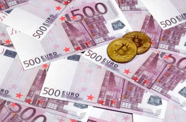 Bitcoins beş yüz euro banknot yığını üzerinde. Geleneksel para cryptocurrency kavramı karşı. Altın sikke üzerinde 500 euro faturaları. Yakın çekim