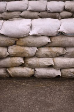 Birçok kirli kum torbası sel savunma için arka plan. Askerî kullanıma yönelik koruyucu kum torbası barikat. Yakışıklı taktik sığınak
