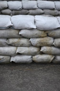 Birçok kirli kum torbası sel savunma için arka plan. Askerî kullanıma yönelik koruyucu kum torbası barikat. Yakışıklı taktik sığınak