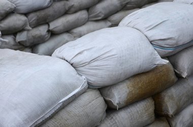 Birçok kirli kum torbası sel savunma için arka plan. Askerî kullanıma yönelik koruyucu kum torbası barikat. Yakışıklı taktik sığınak