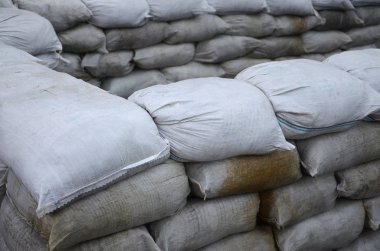 Birçok kirli kum torbası sel savunma için arka plan. Askerî kullanıma yönelik koruyucu kum torbası barikat. Yakışıklı taktik sığınak